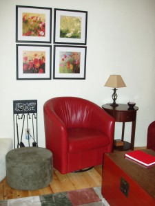 Red living room décor includes two leather chairs